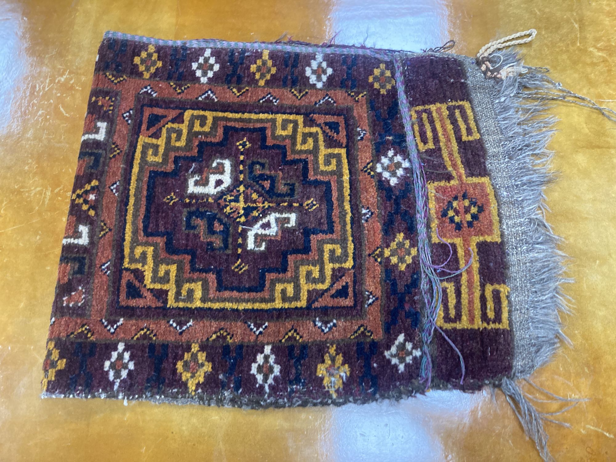 Six Caucasian design mats and a saddlebag, largest 140 x 60cm